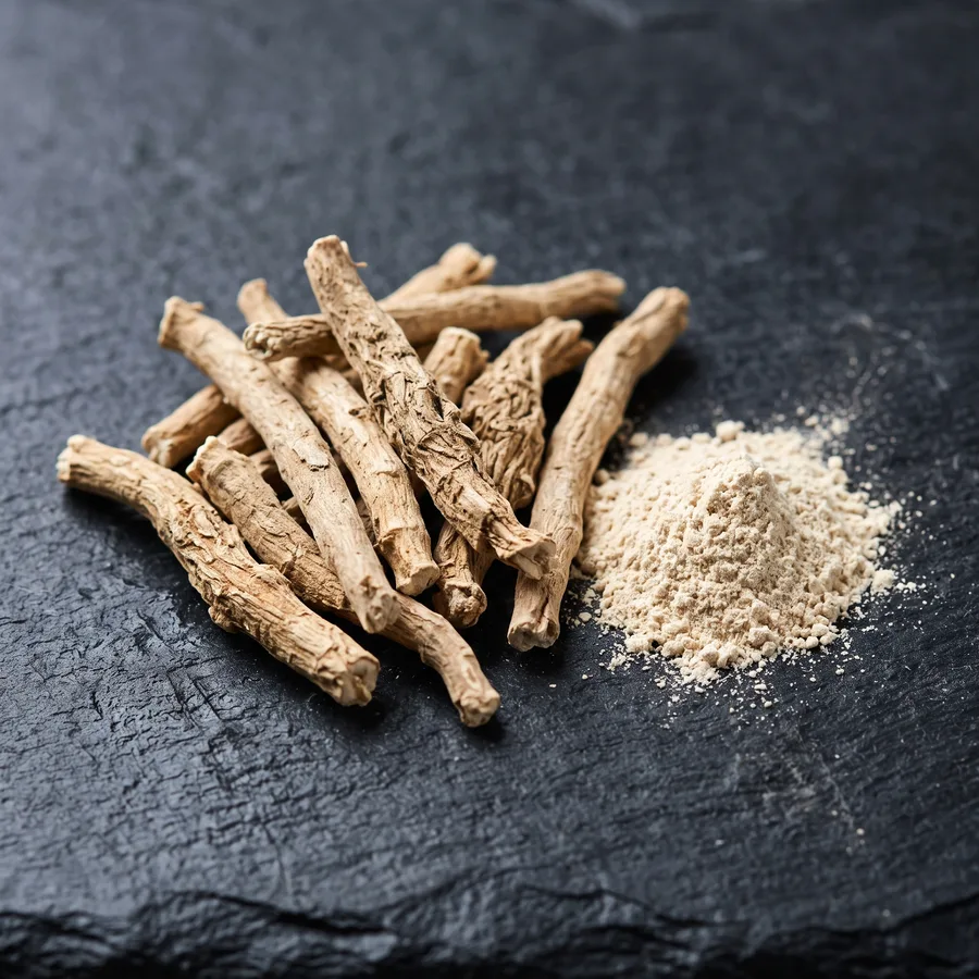 A pile of pale dried roots and a little root powder on slate
